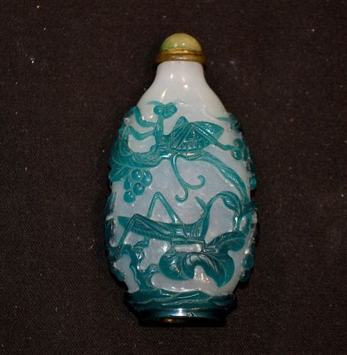 snuff bottle in green and white glass. Carved with praying Mantis