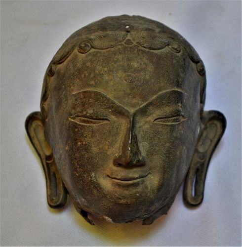 Deity head in hammered bronze