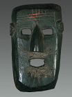 Old black patina mask from West Nepal, Himalya
