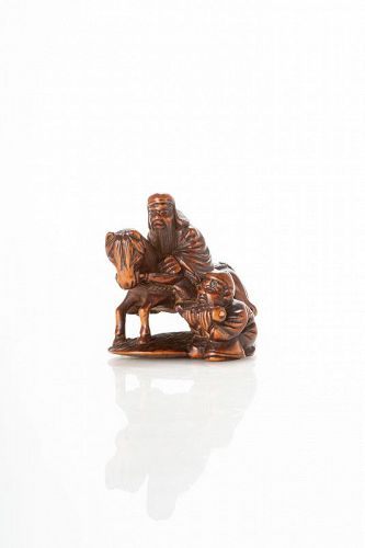 A boxwood netsuke of a wise man on horseback