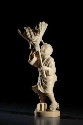 A Japanese Tokyo school ivory okimono depicting a boy on a windy day