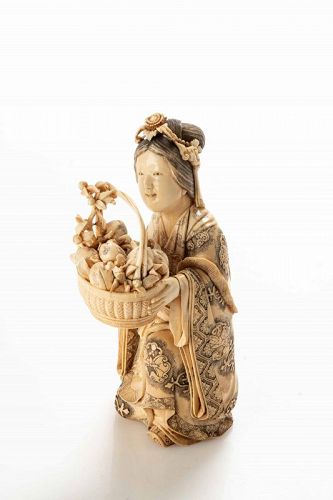A Japanese ivory okimono depicting a young geisha with a basket