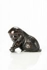 A bronze okimono depicting a study of a puppy playing with a ball