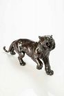 A dark patina bronze okimono depicting the study of a powerful tiger