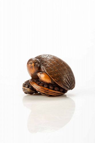 A boxwood netsuke depicting a pair of quails crouching on millet