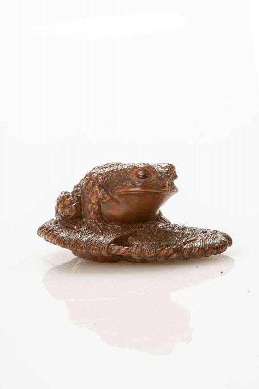 A Boxwood Netsuke Depicting A Toad Resting On A Sandal