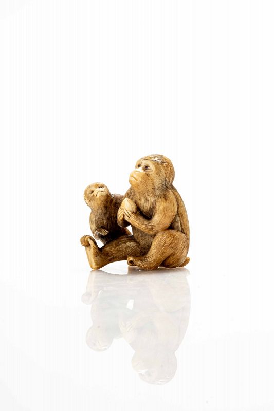 An ivory netsuke depicting a pair of sitting monkeys