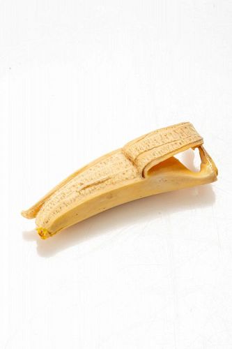 Polychrome ivory okimono depicting the study of a peeled banana