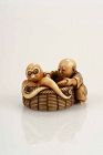 An ivory netsuke depicting a child with a large basket