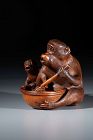 A boxwood okimono depicting two monkeys signed Jigaku