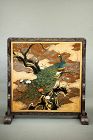 A lacquered wooden screen decorated with a peacock and a landscape