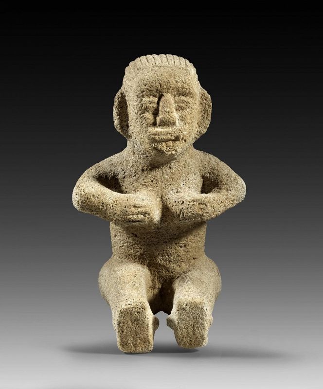 Large Volcanic stone figure of a seated Female, cupping her breasts