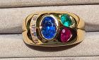An 18K. Gold Ring set with a Blue Sapphire,Diamonds,an Emerald,a Ruby