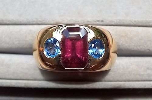 A Fine 18K. Gold Ring set with a Rhodolite and 2 Blue Sapphires.