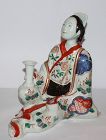 A Japanese Imari figure of a Geisha holding a flower vase.