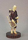 JAPANESE WOOD & WALRUS CARVING OF A FISHERMAN