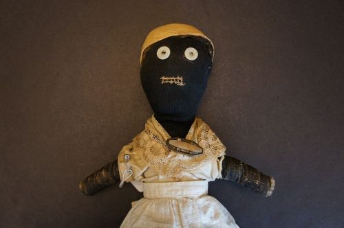 Dear 19th C.little black doll hand sewn great folky face. 17"