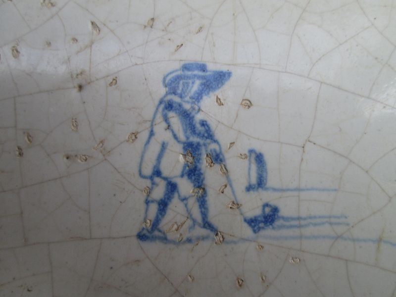 A Dutch delft tile c.1700 depicting a man playing colf.