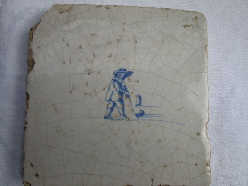 A Dutch delft tile c.1700 depicting a man playing colf.