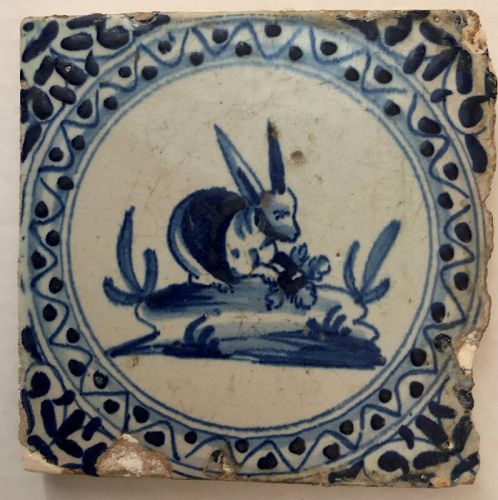 Delft blue and white wall tile of a seated rabbit 17th century