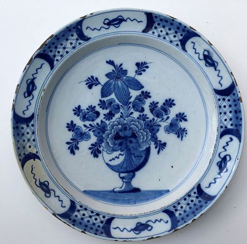Delft charger centering a vase of flowers 18th c. Dutch