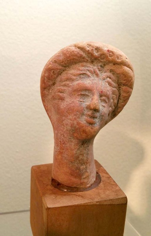 AN ANCIENT GREEK TERRACOTTA FEMALE HEAD