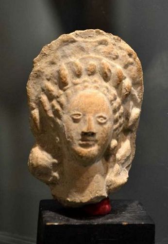 AN ANCIENT GREEK TERRACOTTA FEMALE HEAD