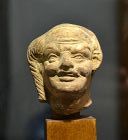 AN EGYPTO=ROMAN TERRACOTTA HEAD OF HARPOCRATES