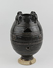 A BLACK GLAZE VASE WITH OPEN WORK AND FOUR LUG HANDLES