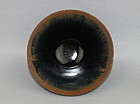 A BLACK GLAZED TEA-BOWL WITH HARE FUR'S EFFECT