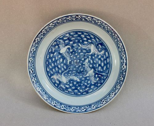 A LATE MING DYNASTY BLUE AND WHITE DISH WITH EGRETS