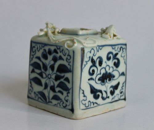 A BLUE AND WHITE SQUARE WATER CONTAINER WITH PAIR OF LIZARD TO THE TOP