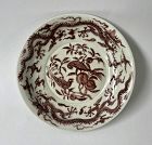 A RARE UNDERGLAZED RED DISH WITH PARROTS AND DRAGONS