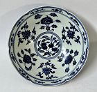 A BLUE AND WHITE CONICAL BOWL WITH FRUITS AND FLOWERS