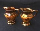 Staffordshire copper lustre cream jugs / pitchers, a pair
