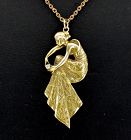 Art Nouveau lady holding diamond pendant in 14k gold