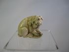 Japanese Carved Netsuke of a Dog Chewing on a Sandal