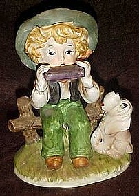 Little boy playing harmonica with hound dog figurine