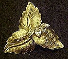 Gold tone leaf pin with rhinestone accents