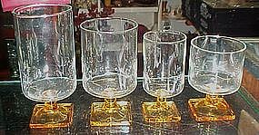 Assorted crystal glasses, square yellow bottoms