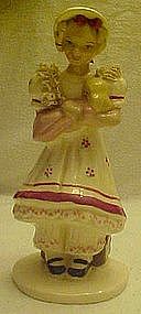 Vintage pottery girl with trunk, holding doll figurine