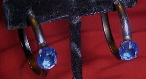 Silver tone hoop earrings with faux blue sapphire,
