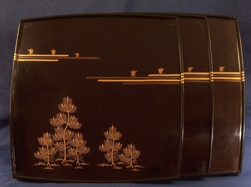 Three matching Japanese lacquer trays and a fourth tray