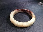 A mottled brown jade carved  bangle