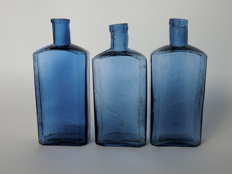 THREE BLUE EMPTY BOTTLES