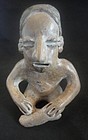 AN UNUSUAL AND APPEALING COMPACT COLIMA SEATED FIGURE