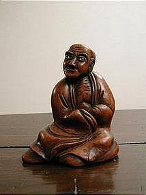 Japanese wooden sculpture of seated man, dated 1823