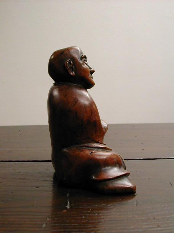 Japanese wooden sculpture of seated man, dated 1823